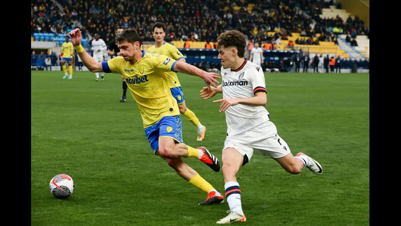 Cầu thủ của Panserraikos vượt qua phòng ngự của Panetolikos trong trận đấu