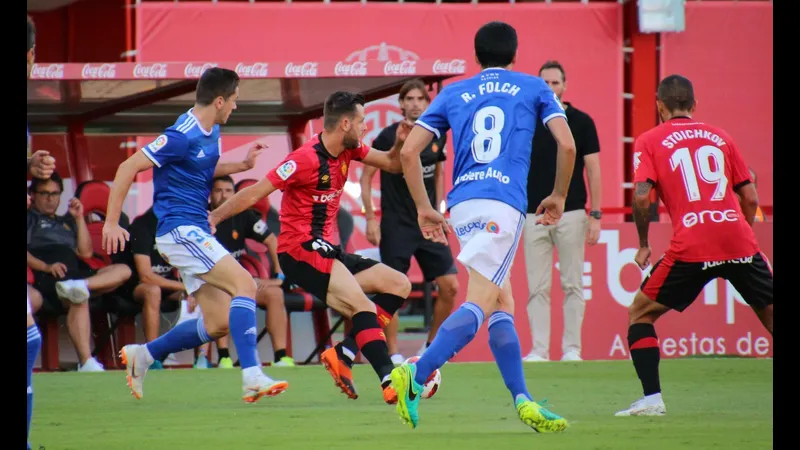 Cầu thủ Real Oviedo vượt qua hậu vệ của đội Mallorca trong trận đấu sôi động.