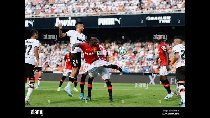 Cầu thủ Valencia dùng kỹ thuật cá nhân vượt qua hậu vệ của Mallorca