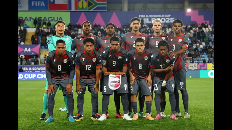 Cầu thủ New Caledonia bứt tốc vượt qua cầu thủ Jamaica trên sân cỏ